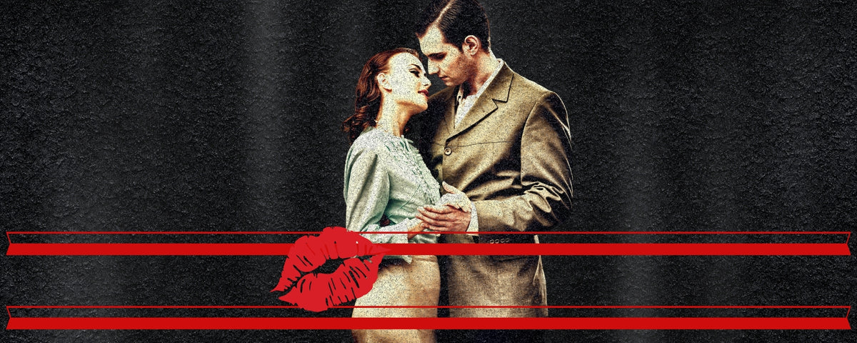 A young man and woman embrace against a black background with a stylised lipstick print in foreground.