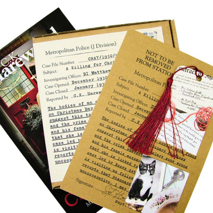 A Killing for Christmas paperback, audio CD boxset and bookmark on white background.