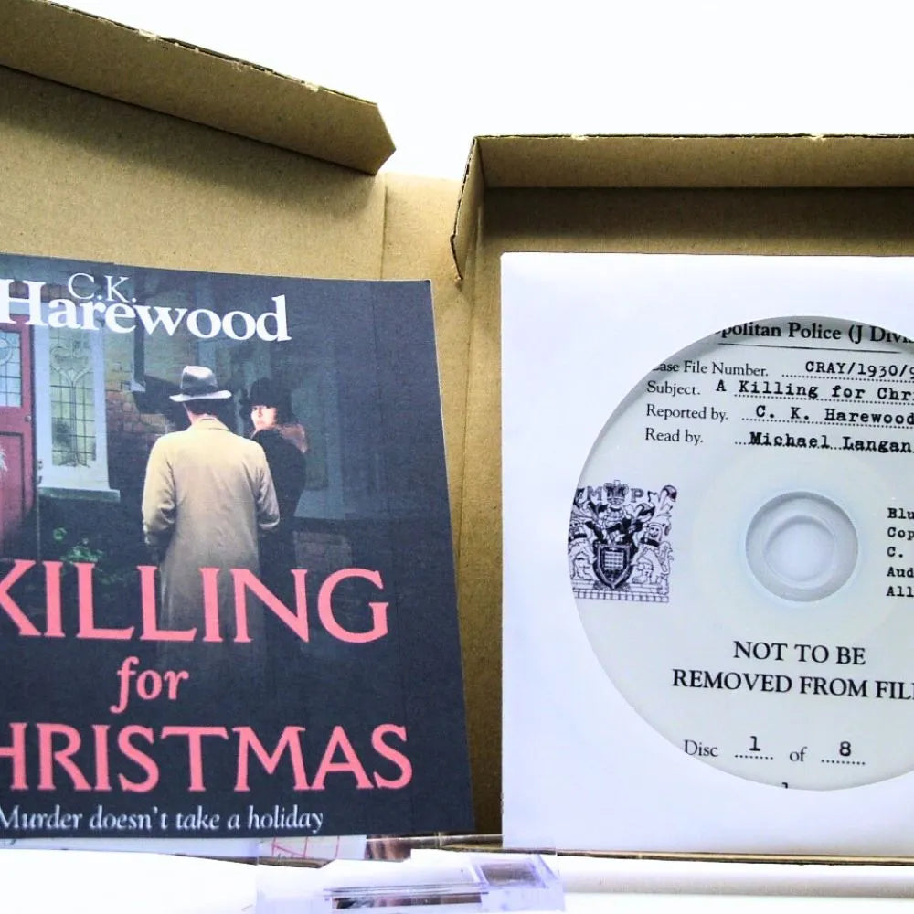 Book titled 'Killing for Christmas' by C.K. Harewood with a CD inside a cardboard box.