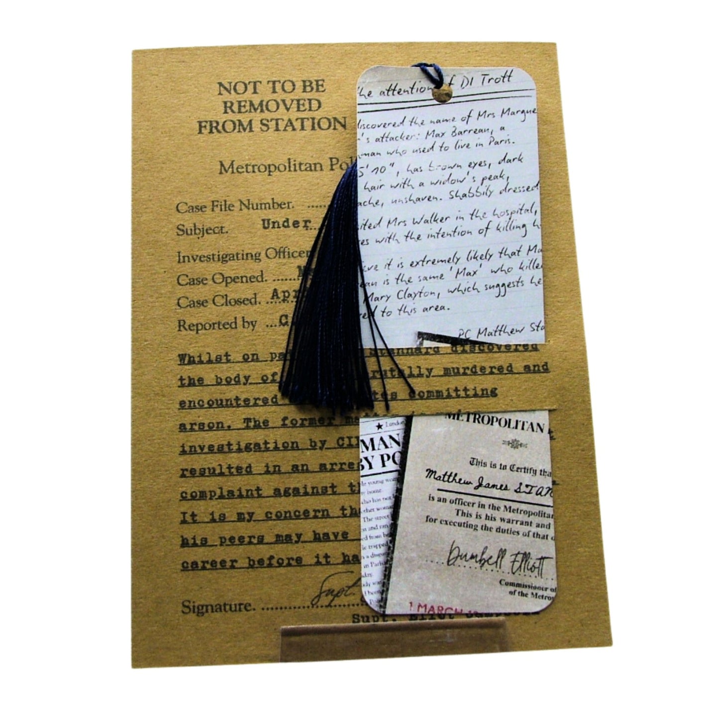 Black tassel bookmark on a vintage-style document with text