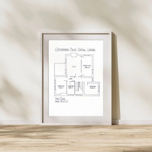 Framed floor plan on a wall with wooden flooring