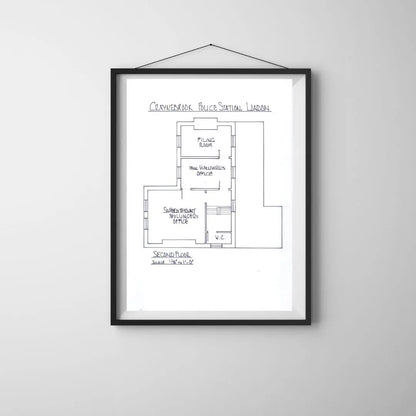 Framed floor plan of a police station on a white wall