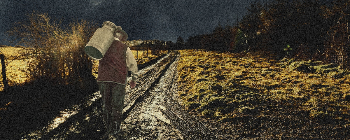 A stylized, painterly scene of a person carrying a large white bucket on their shoulder while walking along a muddy path between grassy fields under a dark night sky.