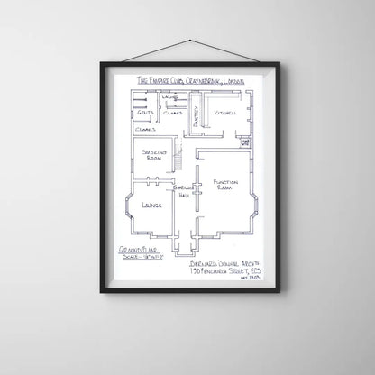 Framed floor plan of a building on a white wall