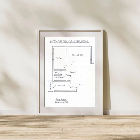 Framed floor plan on a wall with wooden flooring